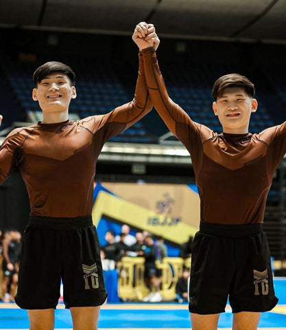 Atletas dos irmãos Niwa com os braços erguidos em uma competição sem kimono.