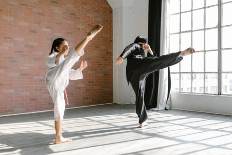 Two women kicking their legs up in kimonos.