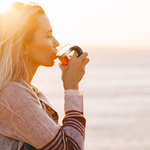 woman sipping warm cbd tea in the sunshine