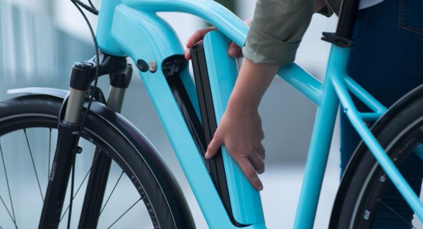 Weiße E-Bike-Batterie mit Person, die diese Batterie entfernt