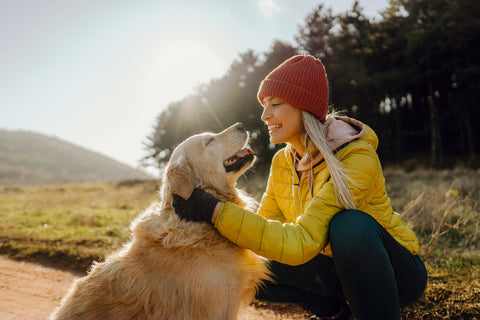 young-woman-taking-a-break-from-running-to-pet-her-golden-retriever,-who-keeps-her-company-during-exercise