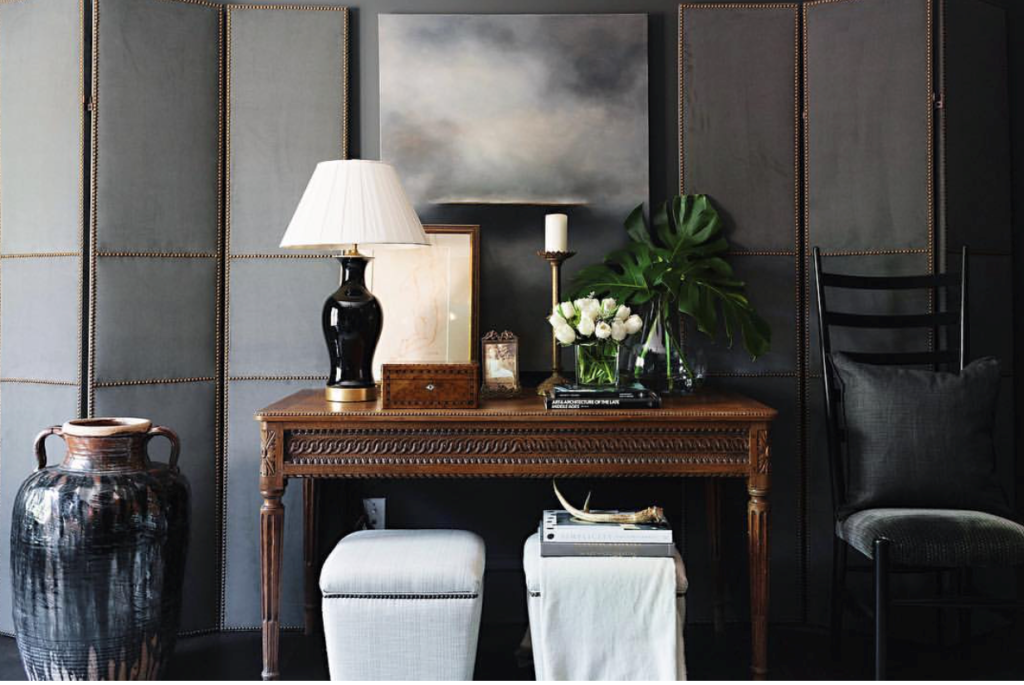 We love to see the pairing of a dark carved antique console with pretty modern upholstery and art.