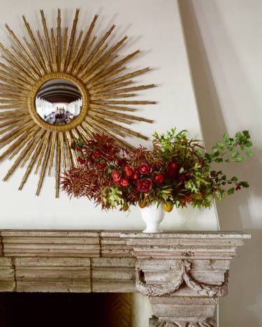 A starburst mirror transcends any season while a wild arrangement by Camille Styles brings the outdoors in. Image via Veranda.