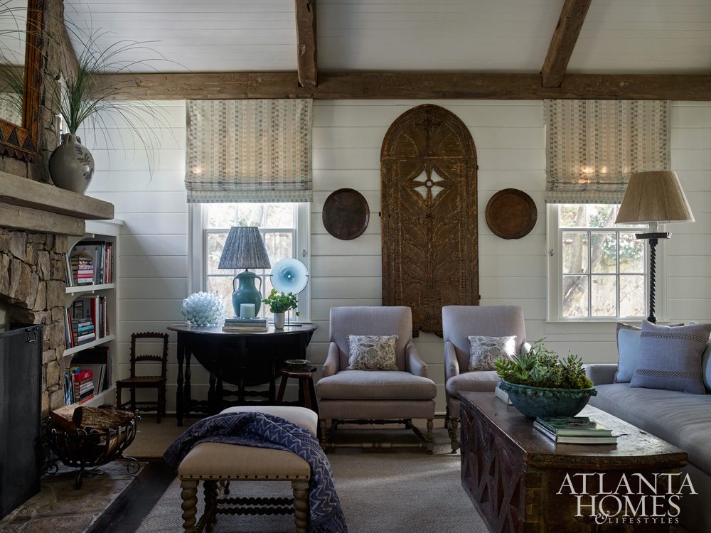 A chic throw and complimenting pillows add a cozy ambiance to this space, image via Atlanta Homes & Lifestyles.