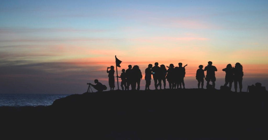 Grupo de pessoas assistindo ao por do sol