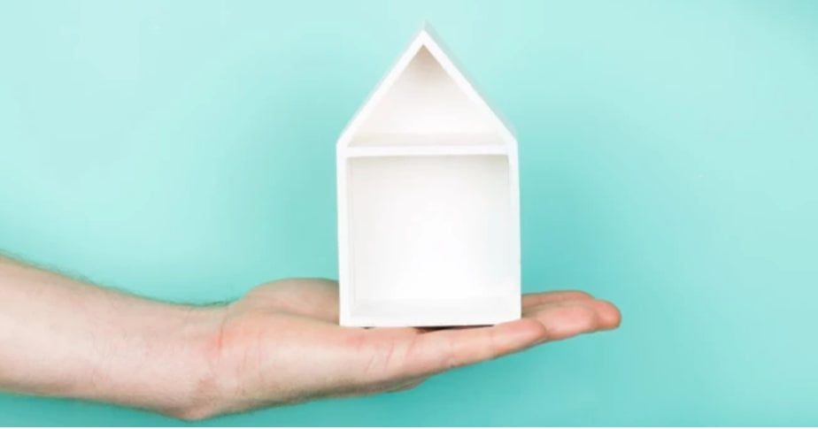 Hand holding a crafted white little house