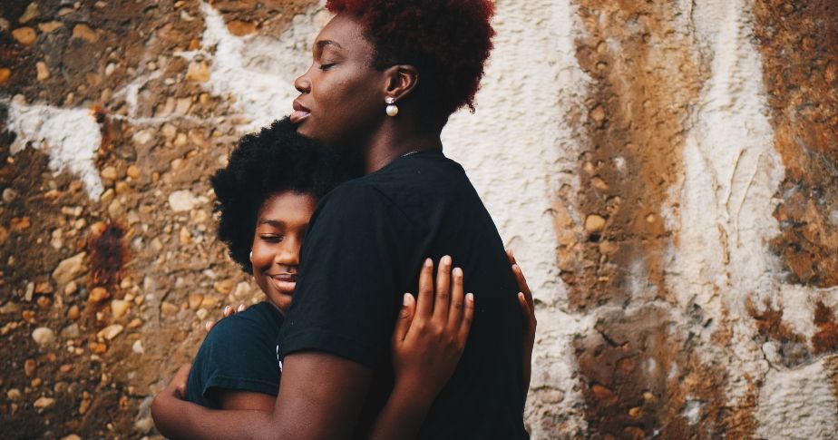 Una mujer negra abrazando a una niña negra