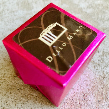 A Dello Mano Luxury Raspberry Hazelnut  Brownie Cube wrapped in  pink efoil