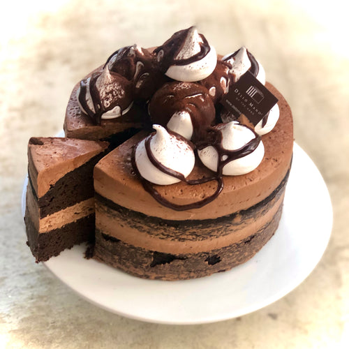 A layered chocolate cake on a white plate