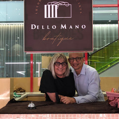 Dello Mano owners Deb and Bien Peralta shown under the Dello Mano logo.