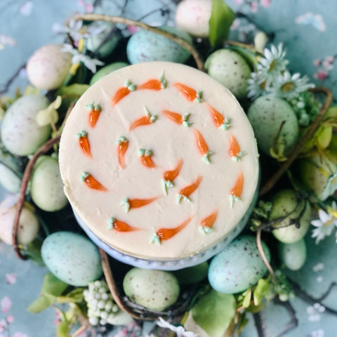 The top of a Dello Mano Easter Carrot Cake surrounded by green Easter eggs.
