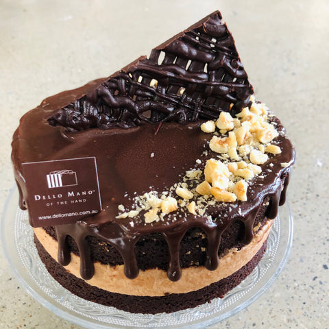 Hazelnut Mousse Cake showing layers of cake and mousse with kibbled hazelnuts and chocolate decoration on top.