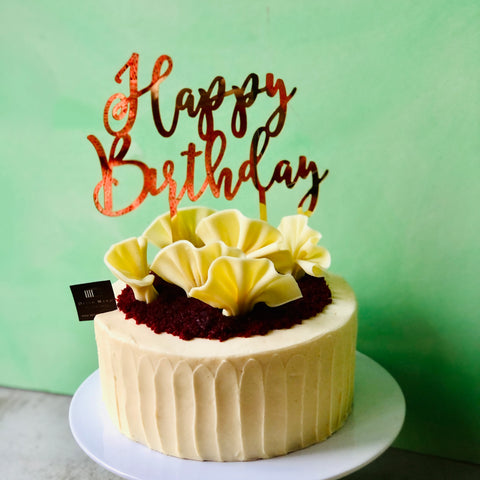 A Red Velvet Birthday Cake on a white stand with green background