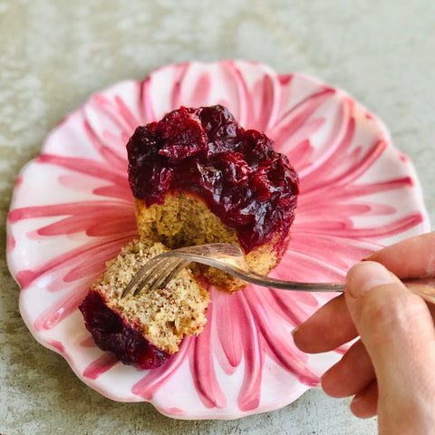 Sour Cherry Gluten Free Cake on a pink plate with hand and fork cutting cake