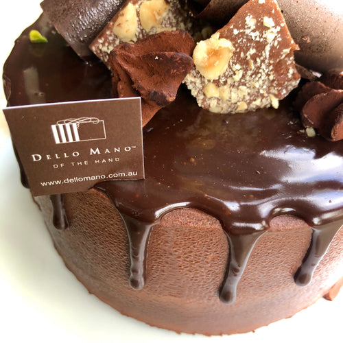 A chocolate Mousse cake with a tag that says Dello Mano of the hand