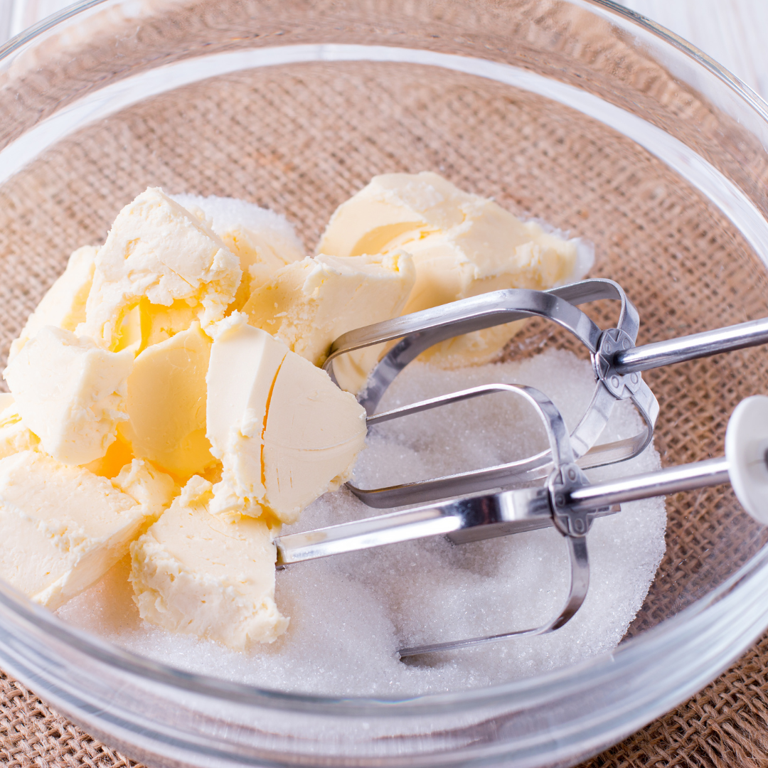 Butter and sugar in a bowl with mixer waiting to be creamed