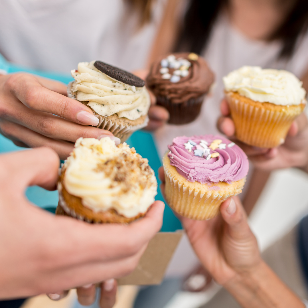a circle of hands holding cupcakes sharing the heartwarming gesture of baking