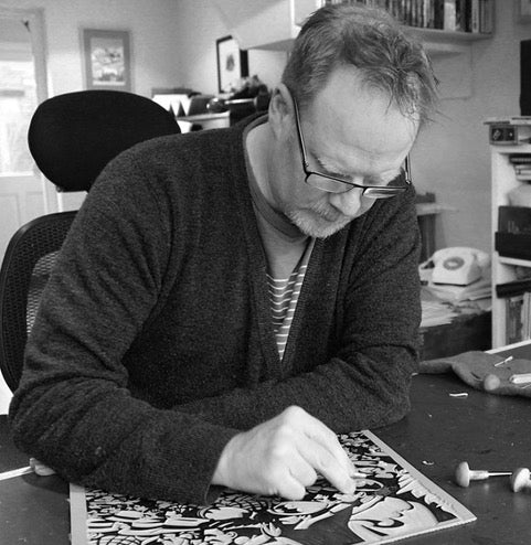 Printmaker Paul Cleden works on a sheet of lino within his studio. 