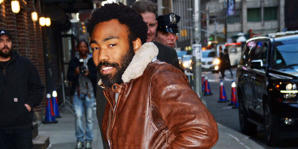 Donald Glover in the city wearing a brown leather jacket