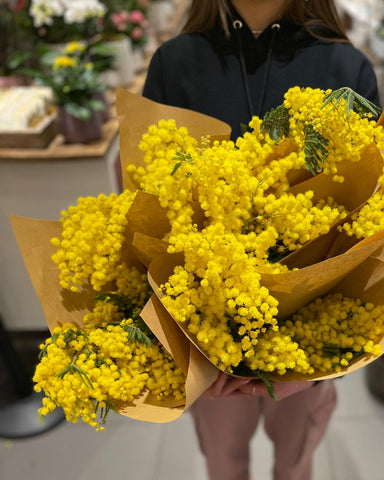 FIORI Oakville Florist Artesian Holding a Bouquet of Mimosa Flowers for IWD