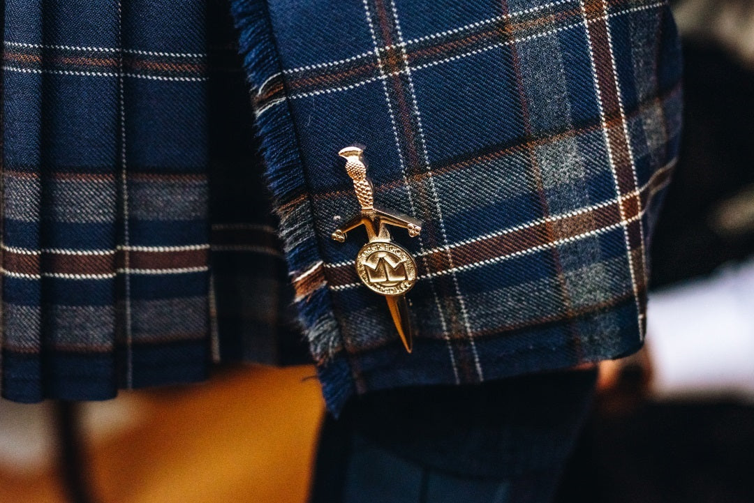 Tartan kilt and kilt pin