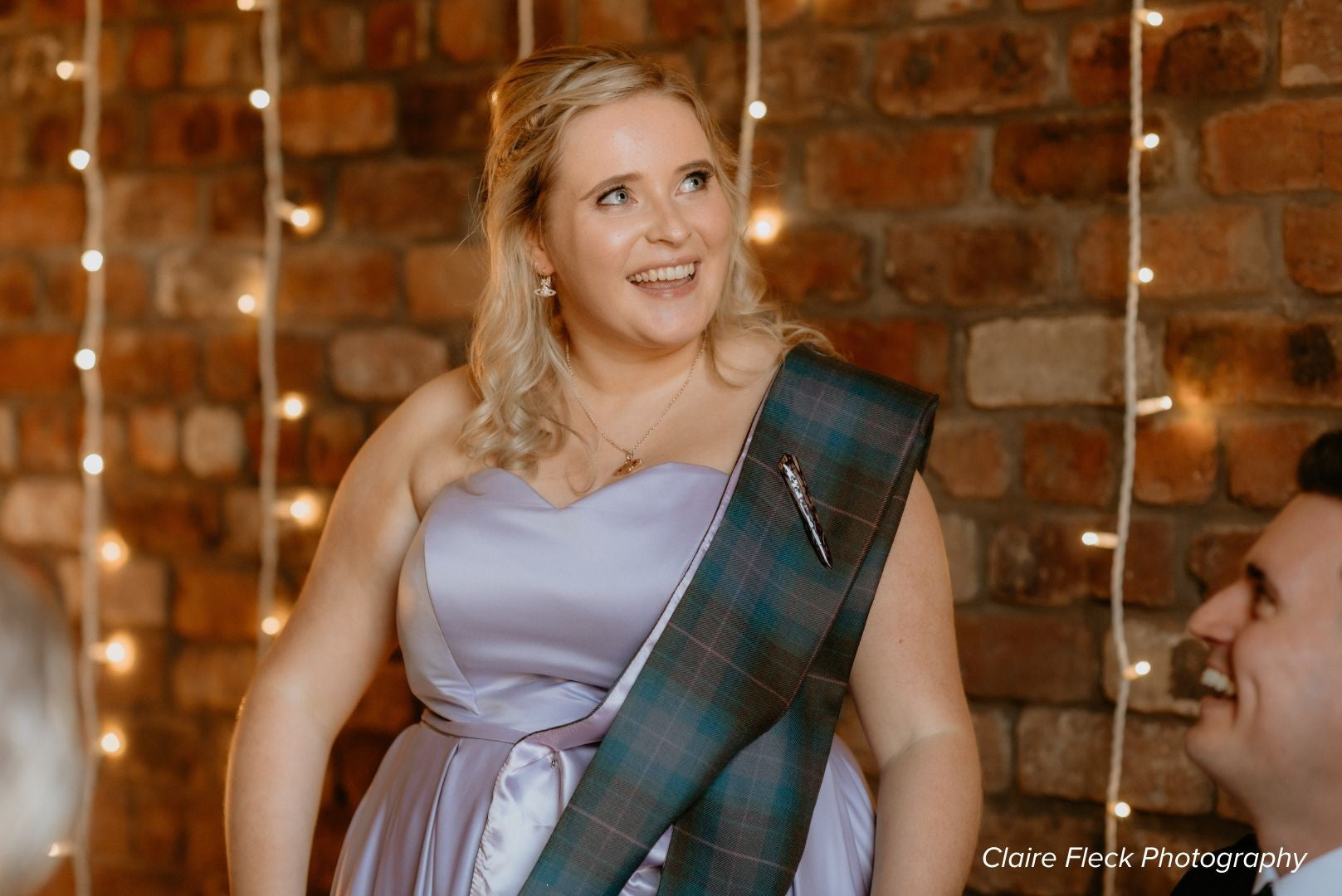 a woman wearing a tartan sash