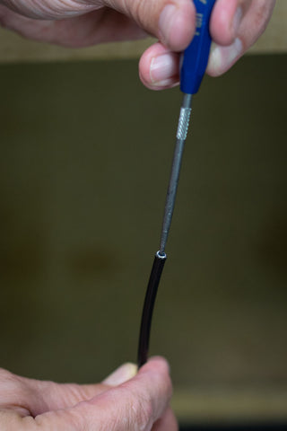 image showing a pick being used to open the cable housing