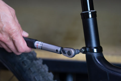 image showing torque wrench being used to tighten seatpost clamp bolt