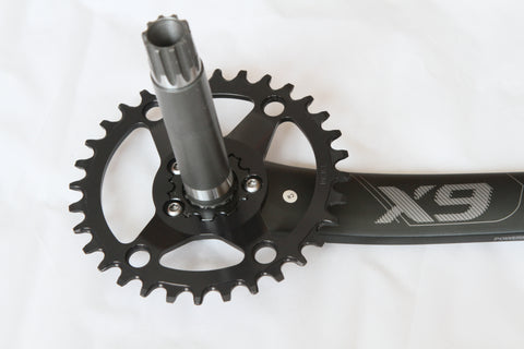 Backside of a direct mount chainring installed on bicycle cranks