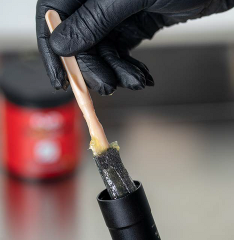 image showing grease being wiped on with a brush