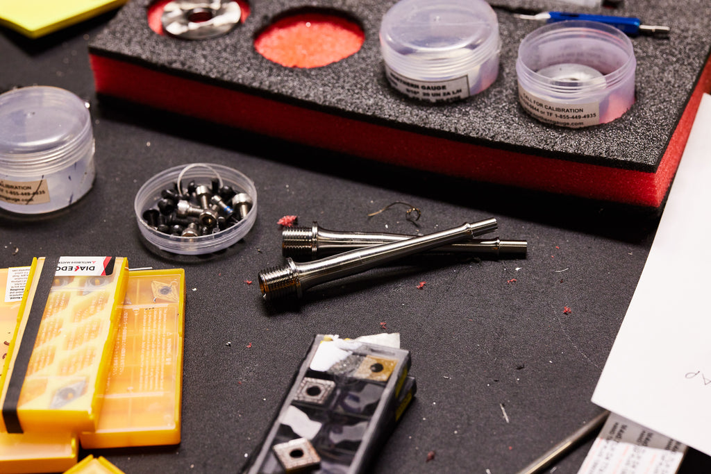 A table in the Wolf Tooth machine shop showing Waveform Pedal Assembly; specifically, the pedal's internal stainless steel axle.