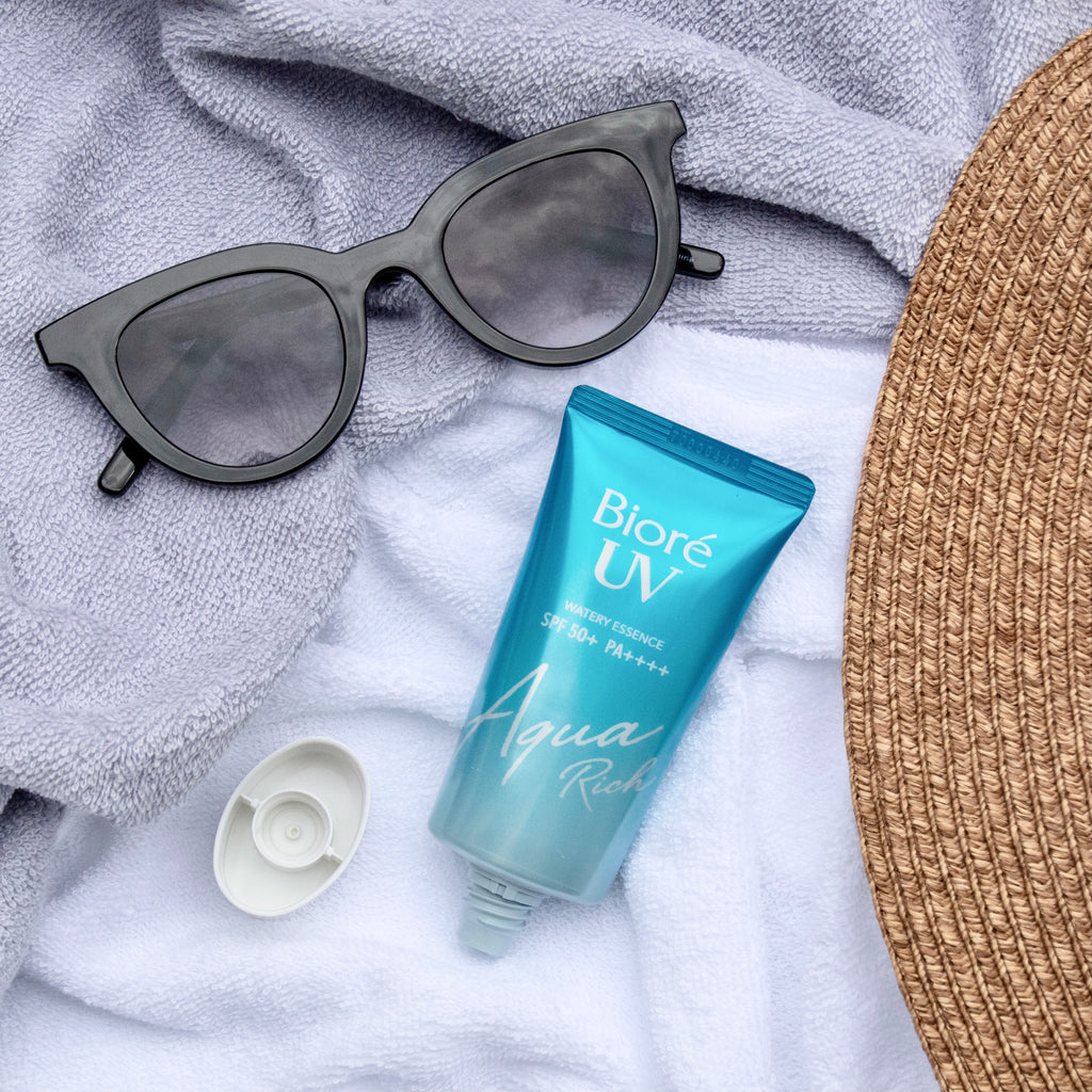 biore uv aqua rich watery essence japanese sunscreen lifestyle photo product lying on the ground cloth with sunglasses high quality product review ビオレ uv アクアリッチ ウォータリーエッセンス