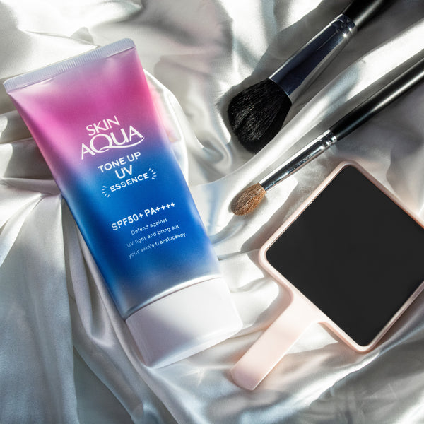 Skin Aqua Tone Up UV Essence 日本防曬生活方式照片產品躺在地上布與化妝工具高品質產品評論 スキンアクアトーンアップ UV エッセンス