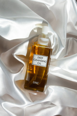 日本面部油清潔劑 DHC 深層清潔油躺在白佈時尚生活方式照片 DHC 薬用ディープクレンジングオイル