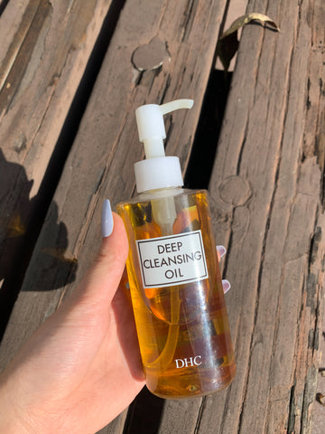 holding japanese facial oil cleanser DHC Deep cleansing  new package unopened lifestyle stylish photo on white background product review DHC薬用ディープクレンジングオイル