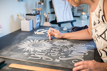 Valerie McKeehan of Lily & Val drawing a chalk image.
