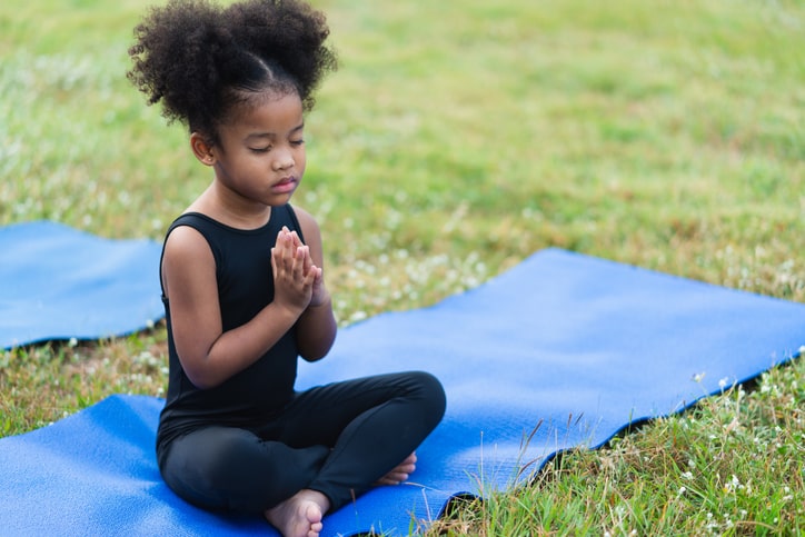 child-doing-yoga-outdoors