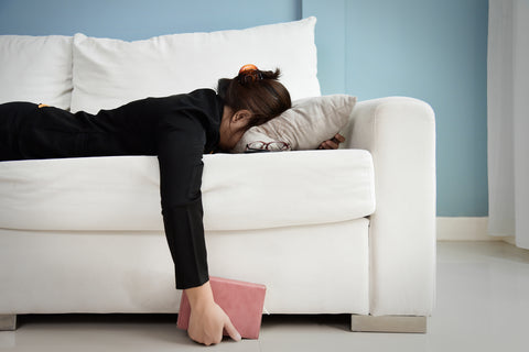 Woman laying on couch to relax after taking CBD for stress relief. 