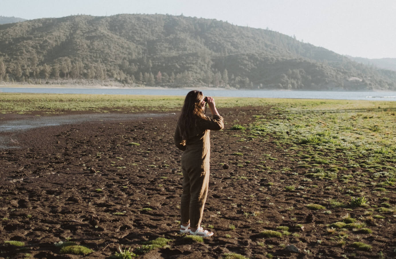 Susan holding binoculars about to view birds in the distance