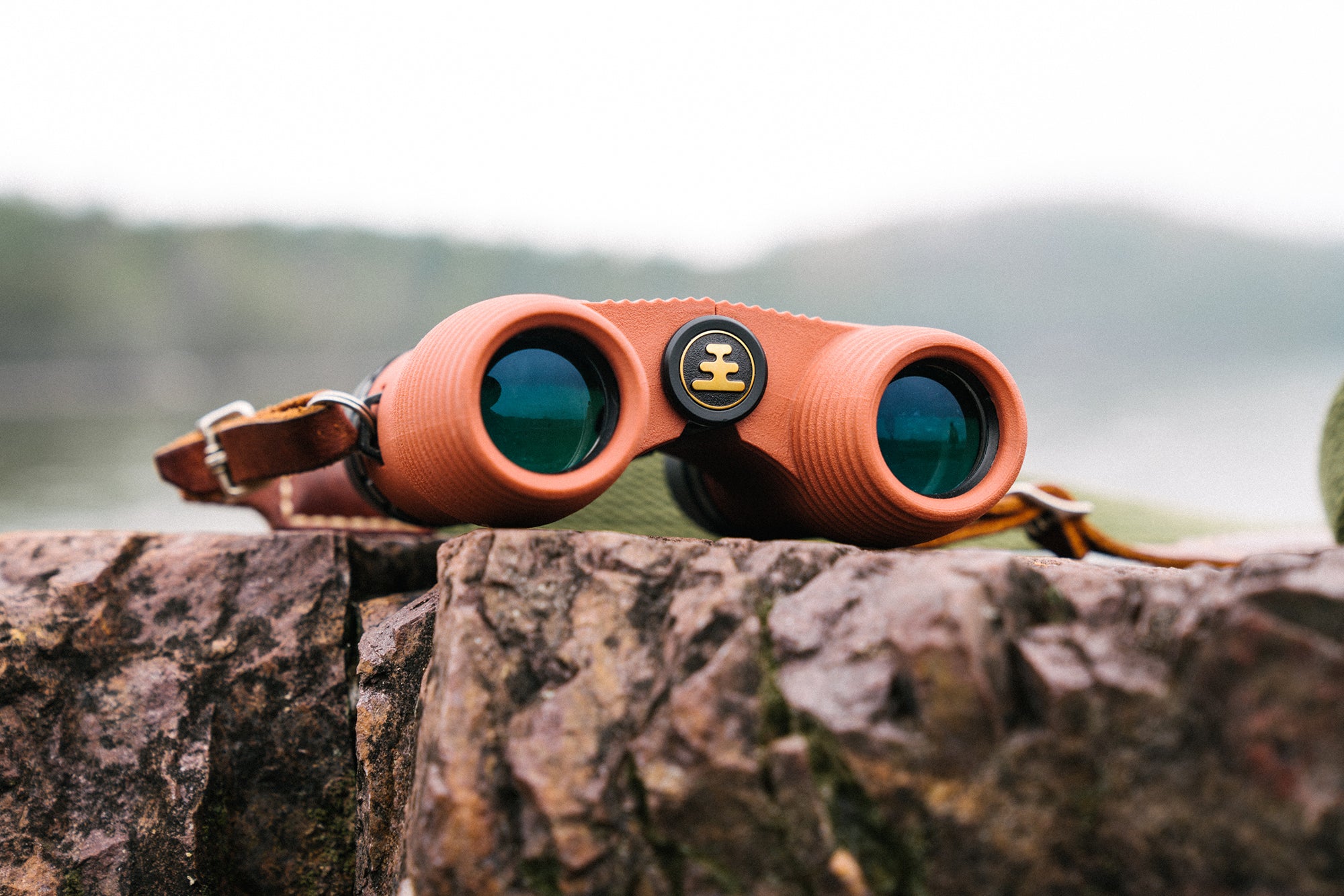 Nocs lightweight waterproof and fogproof binoculars sitting on a rock outdoors