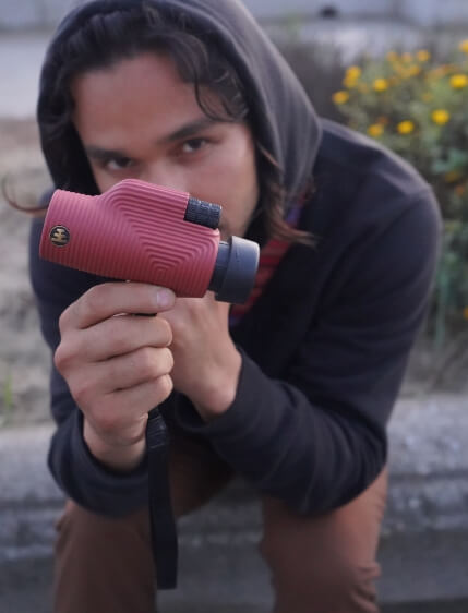 Boom holding a Nocs Monocular up to the camera