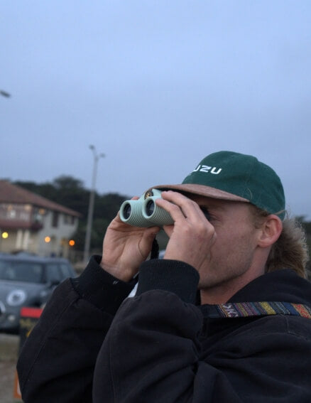 Man looking through some Nocs Binoculars
