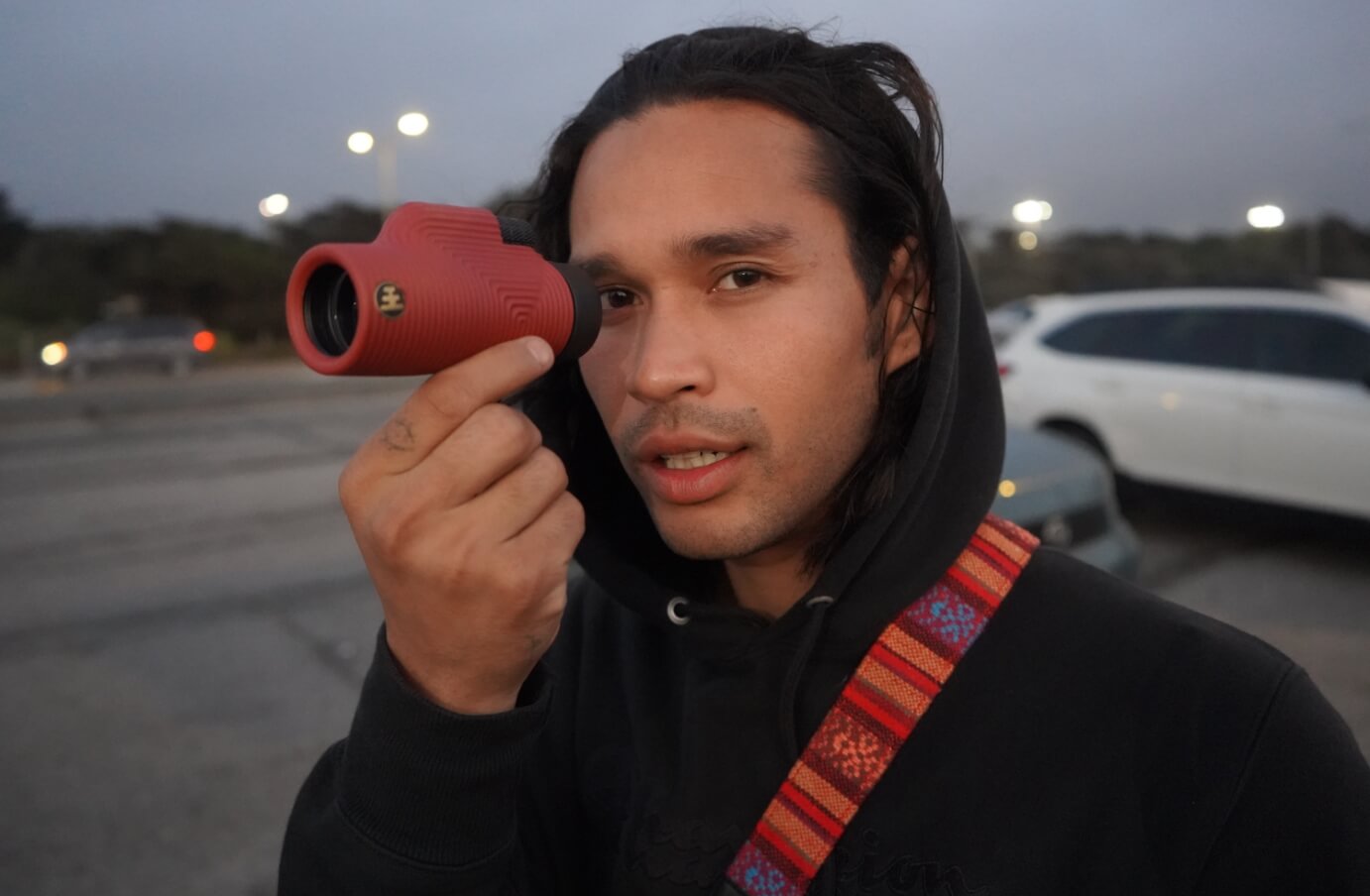 Close up of Boom, holding a pair of Nocs monoculars in front of him towards the camera