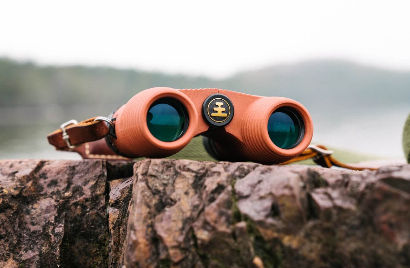a pair of Nocs standard issue 8x25 binoculars set upon a rock