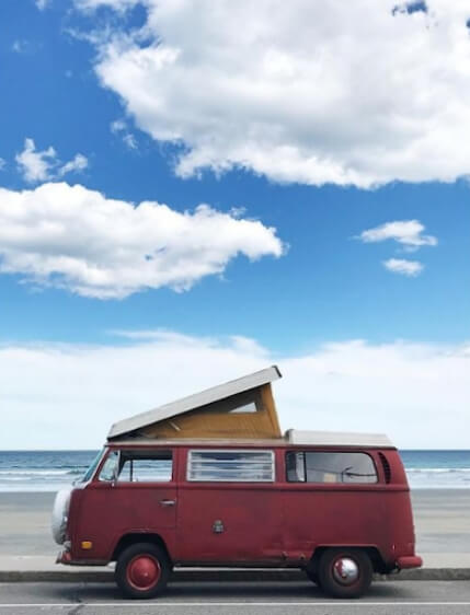 Volkswagon van with the next to the beach with blue skies