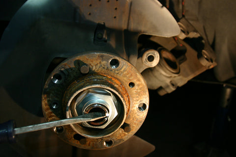 Chisel being used to undo locking notch in axle nut.