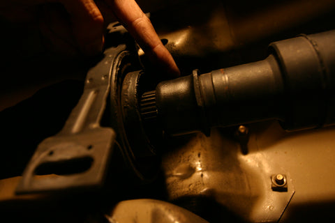 Finger indicating the nut that secures the two halves of the driveshaft together.