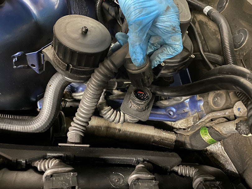Harness being disconnected from the valve cover.