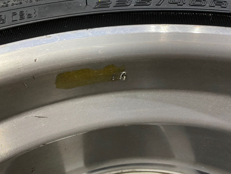 Wheel showing residual tire weight glue and gouge from prying off the wheel weight.