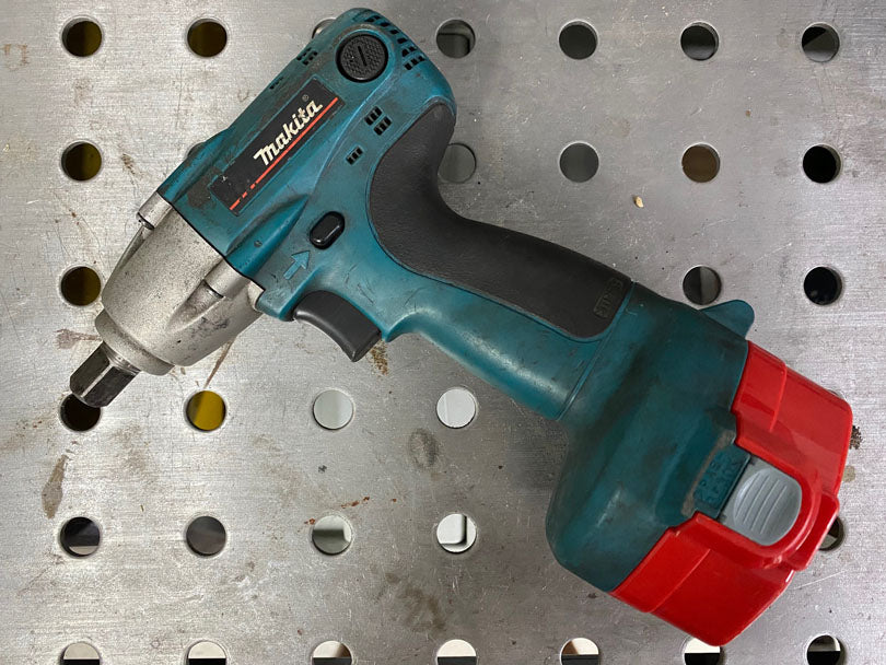 Makita cordless impact wrench resting on a bench top.